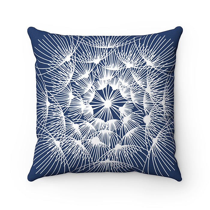 A pillow with a blue background and a white dandelion pattern with the buds extending from the middle of the dandelion head. This pillow features different designs on each side.