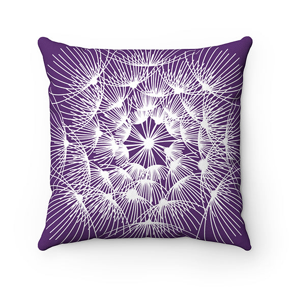 A pillow with a purple background and a white dandelion pattern with the buds extending from the middle of the dandelion head. This pillow features different designs on each side.